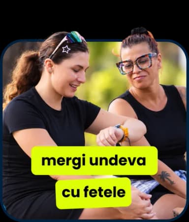 Două femei stau pe iarbă și râd: „mergi undeva cu fetele”